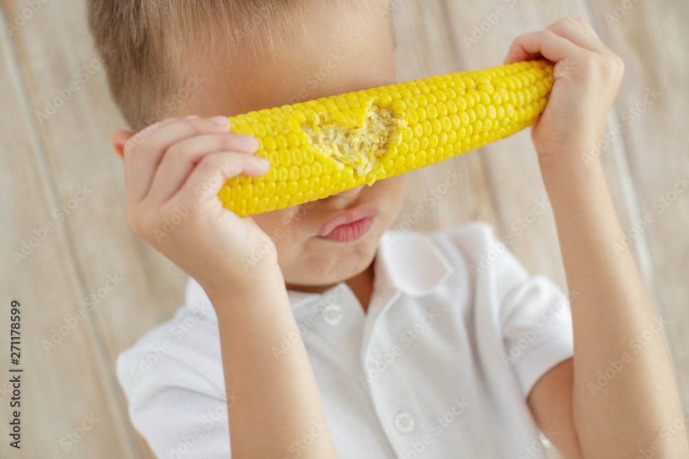 The child eats delicious corn at home The child eats delicious corn at home