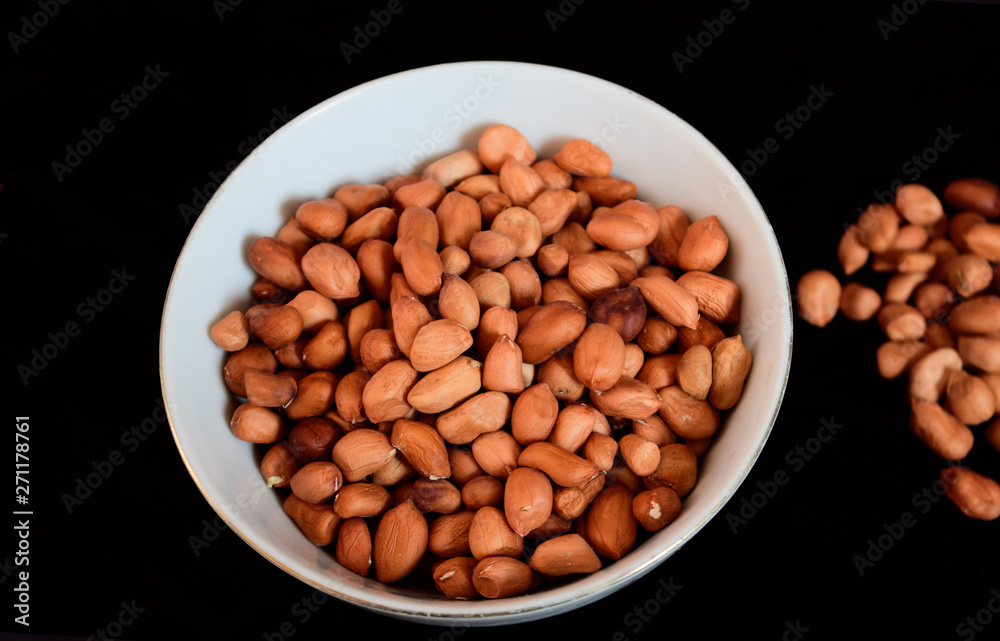 Peanut seeds on a plate with a blank black background Peanut seeds on a plate with a blank black background