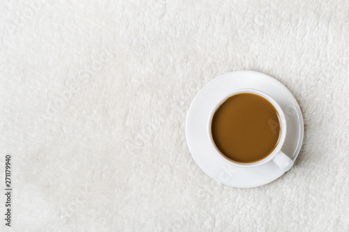 Cup of coffee on white fur. Autumn or Winter minimal cozy background