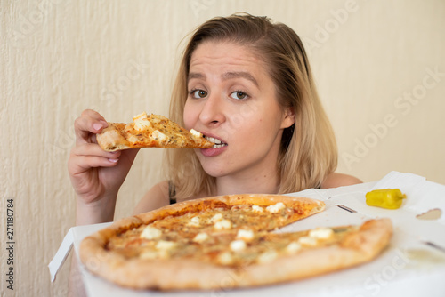 Portrait of a woman eating pizza. Beautiful young woman in black underwear eating pizza