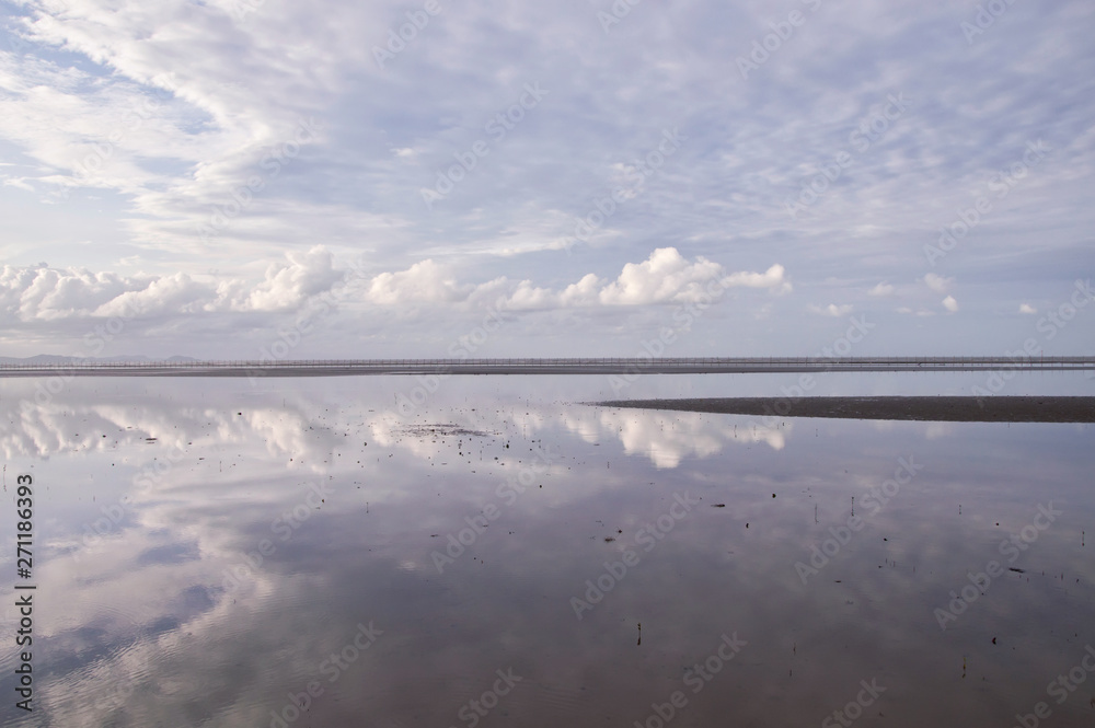 Obraz premium Low tide at sea with blue sky