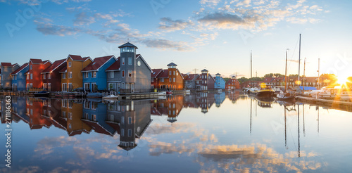 Tranquil dawn at colorful wooden houses in a small harbor in the Netherlands.  Living at the waterfront in Groningen.