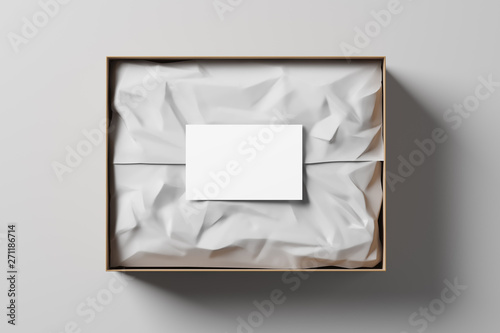 Open gift box with white wrapping paper and business card on a light background. Business gift. Mock up. Top view. 3d rendering