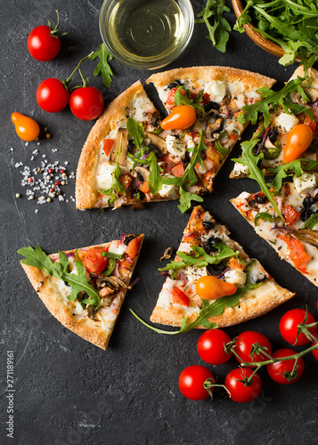 Vegetable italian pizza with tomatos on black background