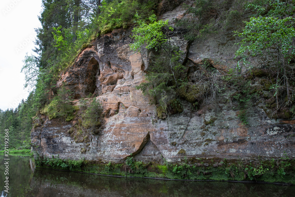 City Straupe, Latvian Republic. Red rocks and river Brasla. Green and overgrown forest. Jun 1. 2019 Travel photo.