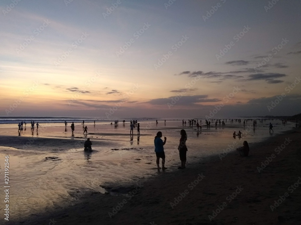 people on the beach at sunset in Bali, Indonesia 