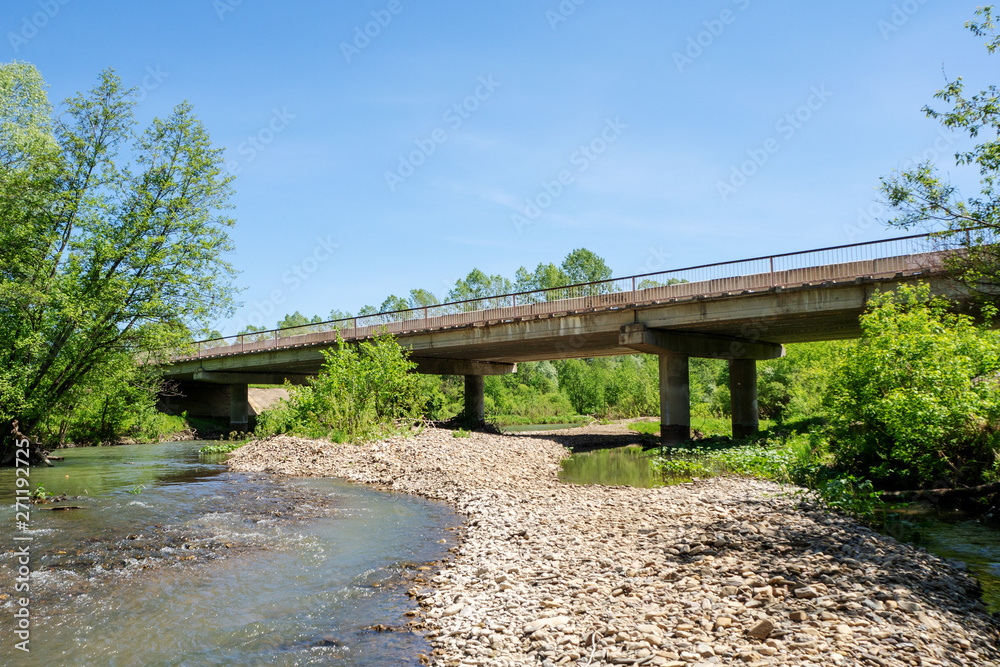 Concrete bridge over a small river. Summer landscape on a sunny day. Concrete bridge over a small river. Summer landscape on a sunny day.