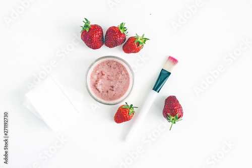Homemade strawberry facial mask. Next to fresh strawberries, cotton napkins, brush, cosmetic, sponge and other ingredients. Top view, white background. The concept of natural skin care