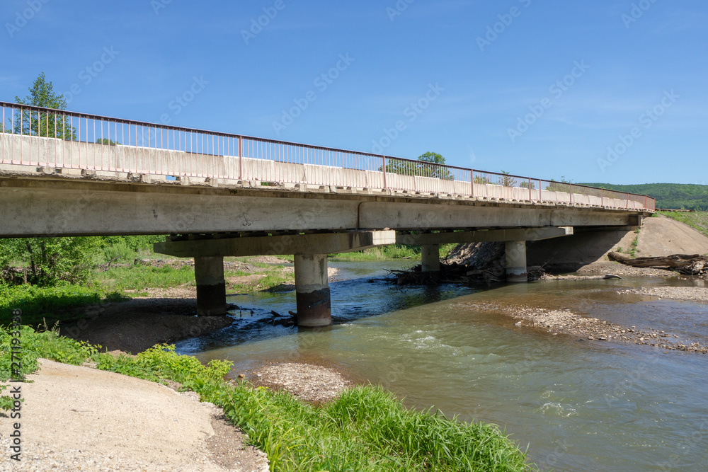 Reinforced concrete road bridge over a picturesque river. Close-up. Reinforced concrete road bridge over a picturesque river. Close-up.