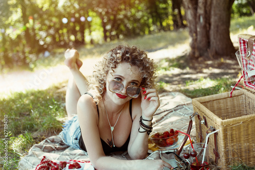 Blonde curly hair girl on summer berry picnic playful mood photo