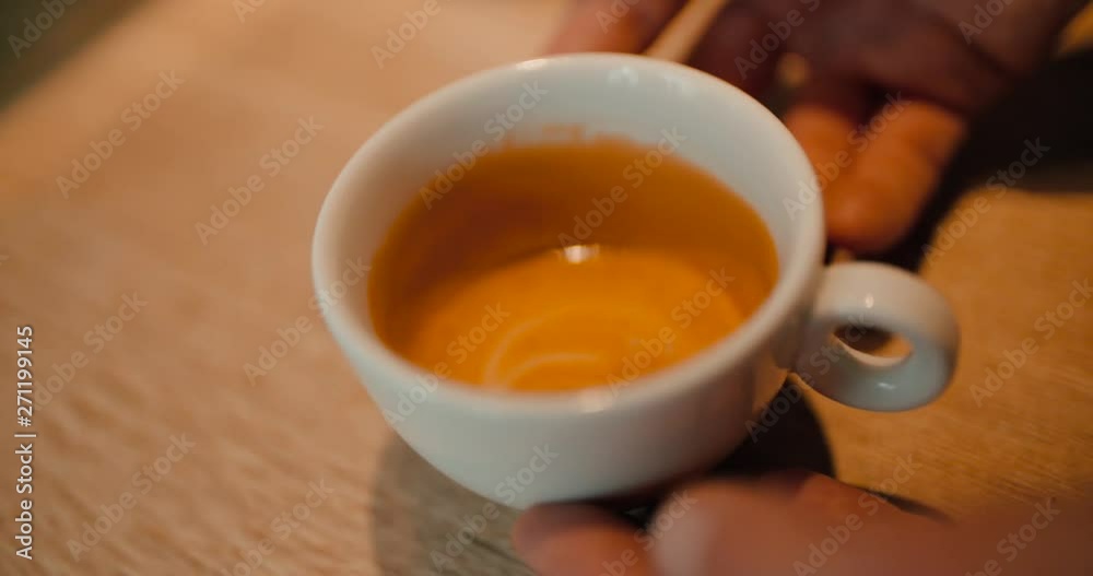 Slow motion of pouring milk into a cup of coffee on an old wooden table, top view Slow motion of pouring milk into a cup of coffee on an old wooden table, top view
