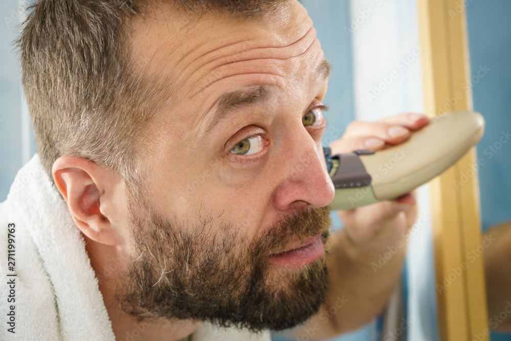 Obraz premium Man shaving trimming his beard