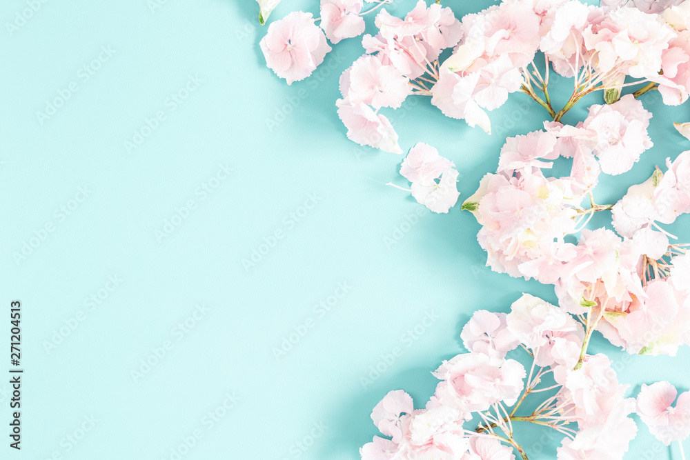 Flowers composition. Frame made of pink and white flowers on pastel blue background. Flat lay, top view, copy space, square