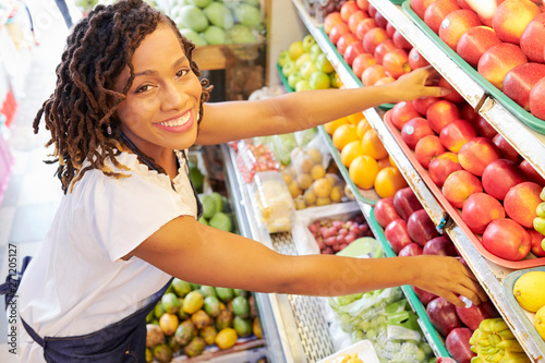 Pretty smiling Black woman working at fruit department at grocery store