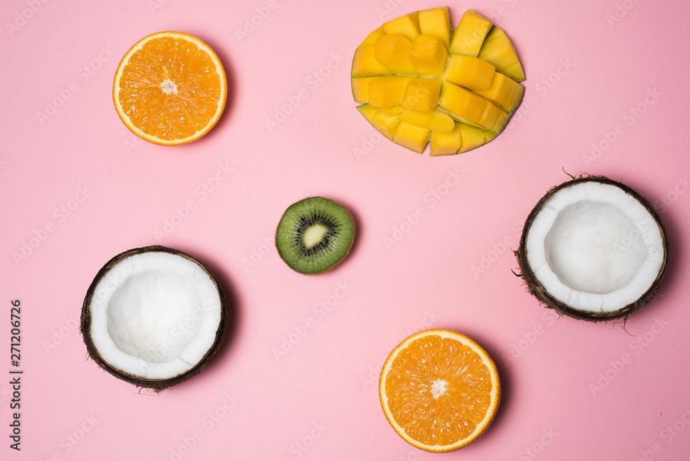 Tropical fruits. Coconut, orange, mango, kiwi on a pink background. Summer season