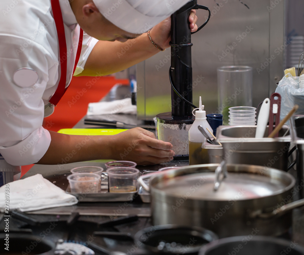 Chef blending meat in hand stick blender Chef blending meat in hand stick blender