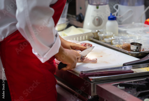 Chef cutting raw fresh chicken on a plastic cutting board. Homemade cooking food