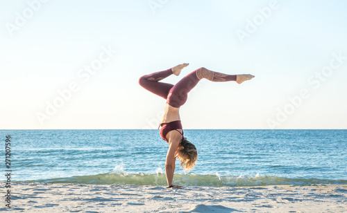 caucasian healthy adult woman with beautiful body doing yoga at sunrise on the beach, yoga poses