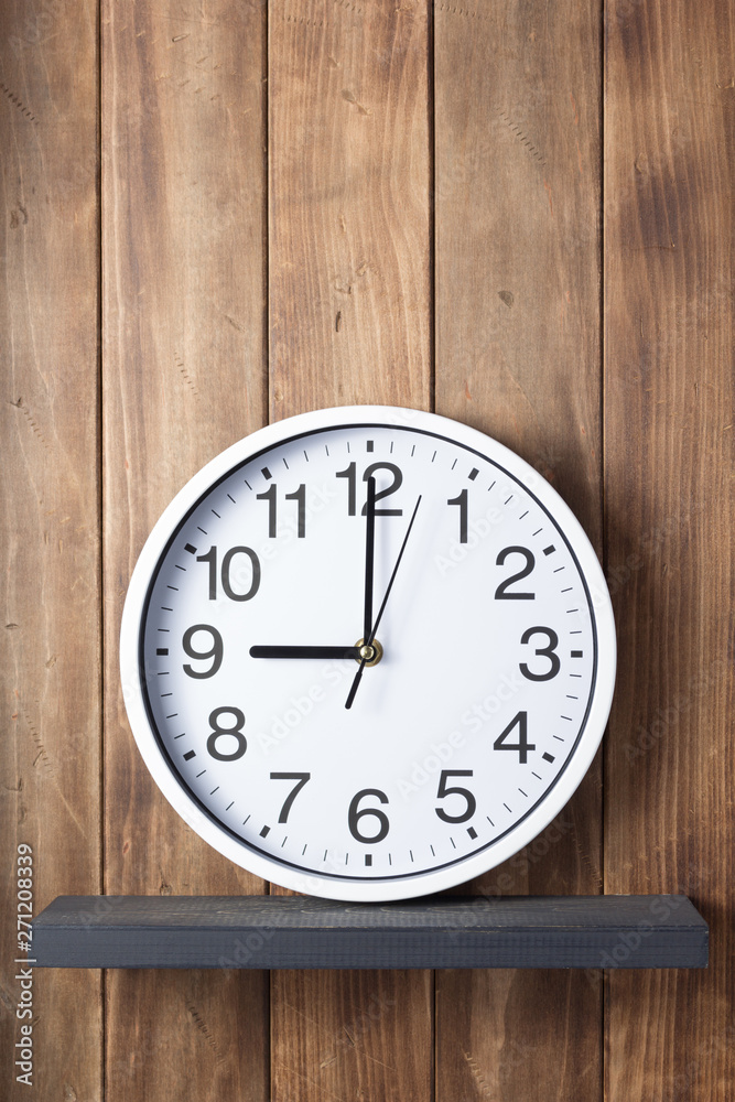 wall clock at shelf on wooden background wall clock at shelf on wooden background