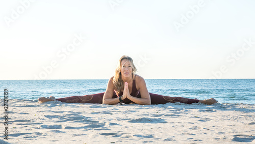 caucasian healthy adult woman with beautiful body doing yoga at sunrise on the beach  yoga poses