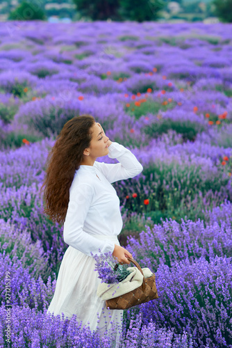 Fototapeta Naklejka Na Ścianę i Meble -  young woman is in the lavender flower field, beautiful summer landscape
