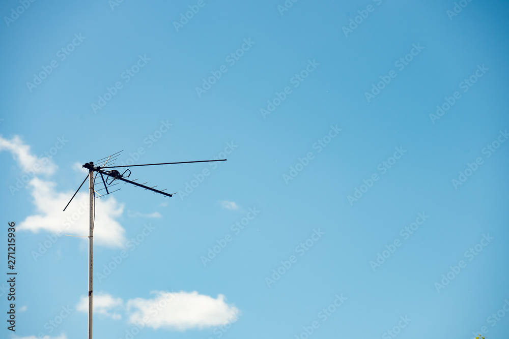 TV antenna against the sky with clouds