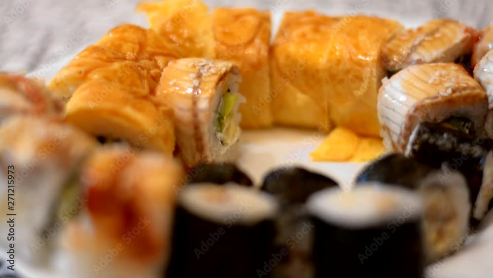 baby hand sushi or japanese roll with raw fish fork in a restaurant closeup baby hand sushi or japanese roll with raw fish fork in a restaurant closeup