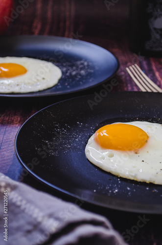 Fried eggs on black plate