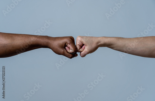 Fist of different skin colors giving fist bump. Conceptual image of race tolerance and stop racism © SB Arts Media