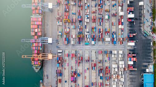 aerial top view of logistics import and export transportation of Container Cargo ship with working crane bridge in shipyard at the port, industrial context