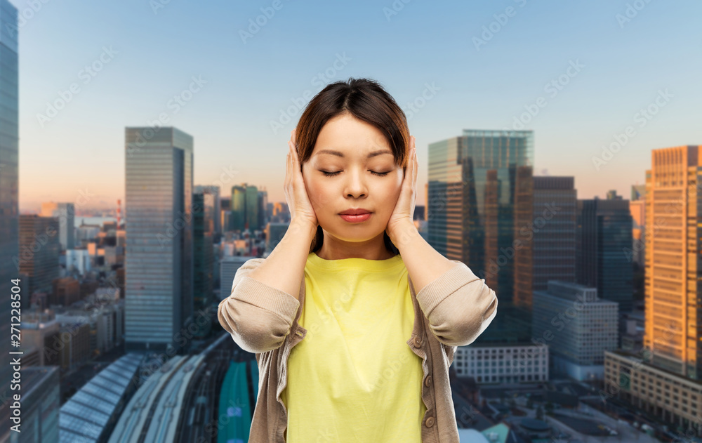 people, emotion and stress concept - asian young woman closing ears by hands over tokyo city background people, emotion and stress concept - asian young woman closing ears by hands over tokyo city background