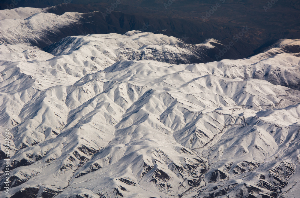 Fototapeta premium Snowy mountains view from plane during winter, Iranian Highlands