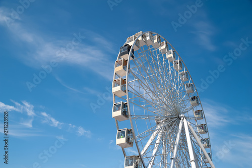 Ferris wheel on blue sky with white clouds background. photo