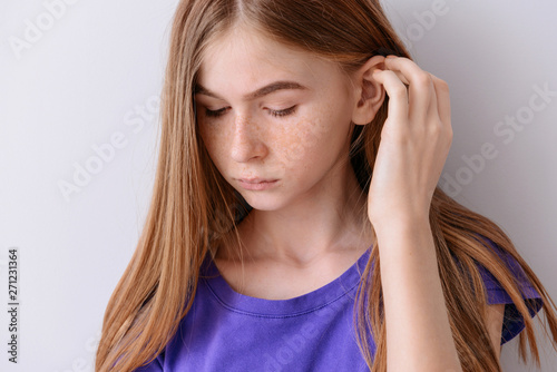 Sad teenage girl on light b...