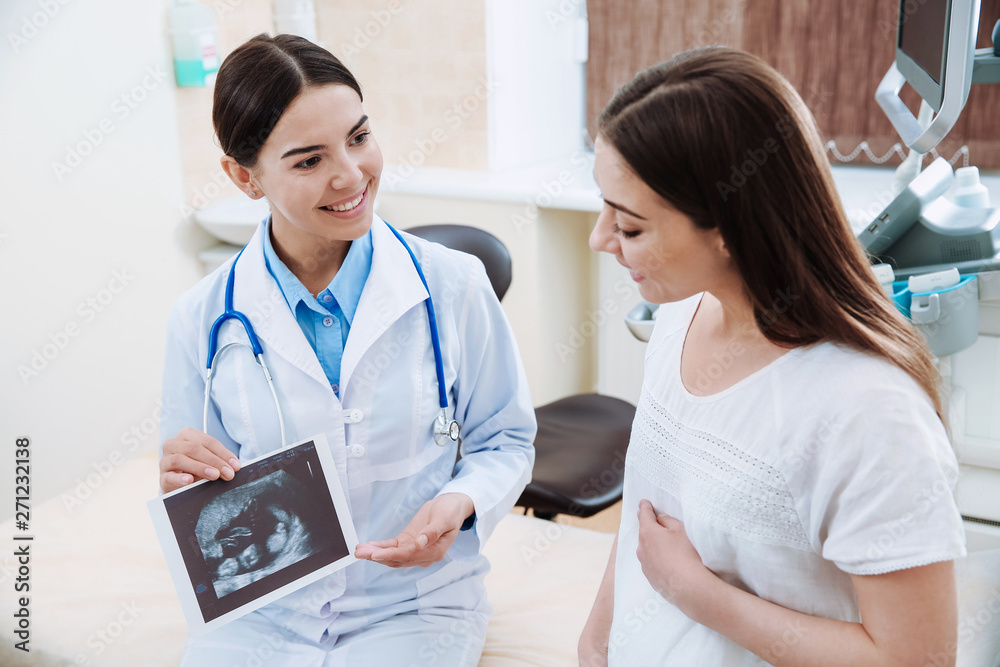 Female ultrasonographer working with pregnant woman in modern clinic Female ultrasonographer working with pregnant woman in modern clinic