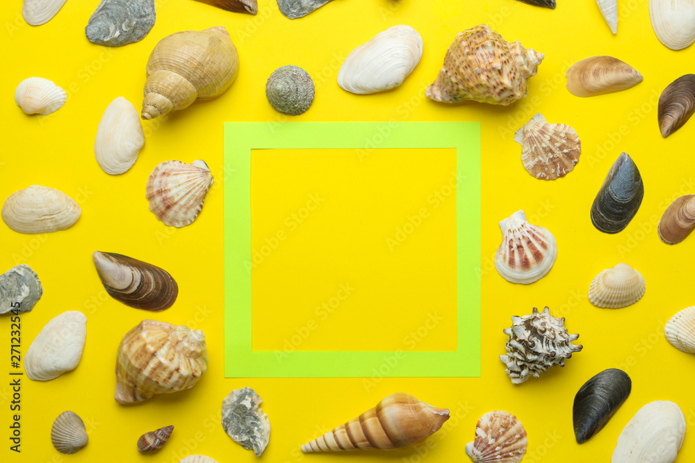 Summer frame. Paper frame for your text and seashells on a bright yellow background. top view