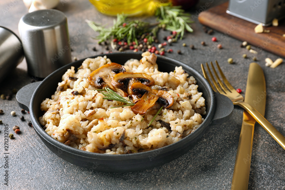 Frying pan with tasty risotto on grey table Frying pan with tasty risotto on grey table