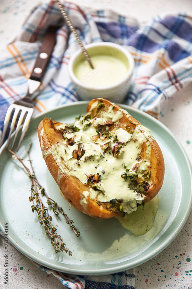 Plate with tasty stuffed potato and sauce on light table Plate with tasty stuffed potato and sauce on light table