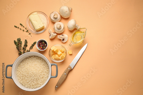 Raw ingredients for risotto on color background