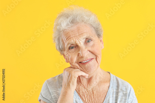 Portrait of senior woman on color background