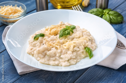 Plate with tasty risotto on wooden table