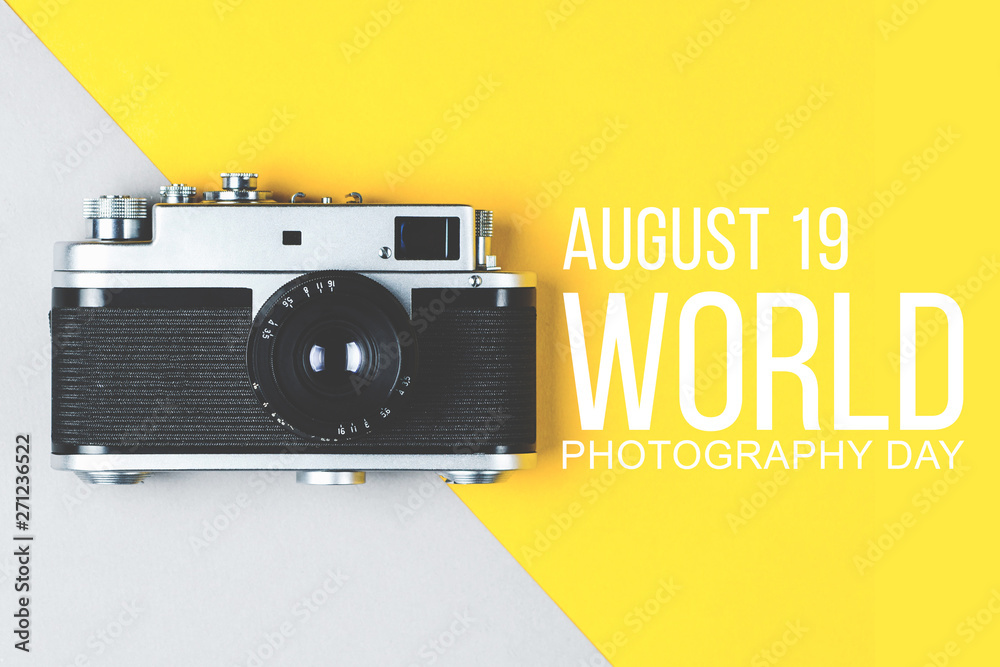 Old retro photo camera on grey-yellow background. World photography day poster - obrazy, fototapety, plakaty 