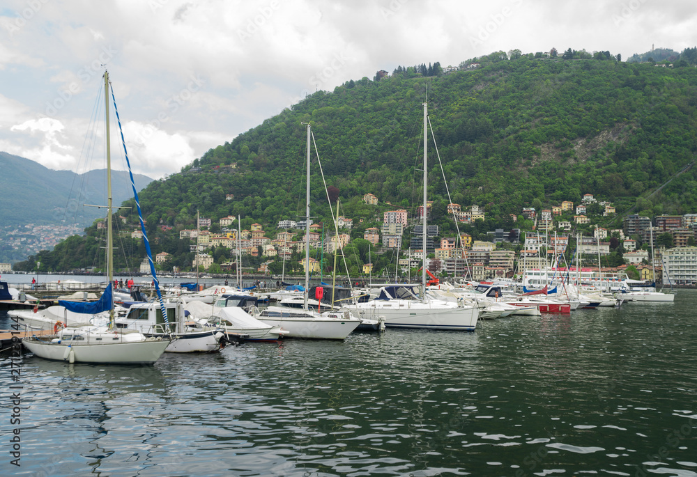Many yachts and boats in the harbor of Como, Italy.