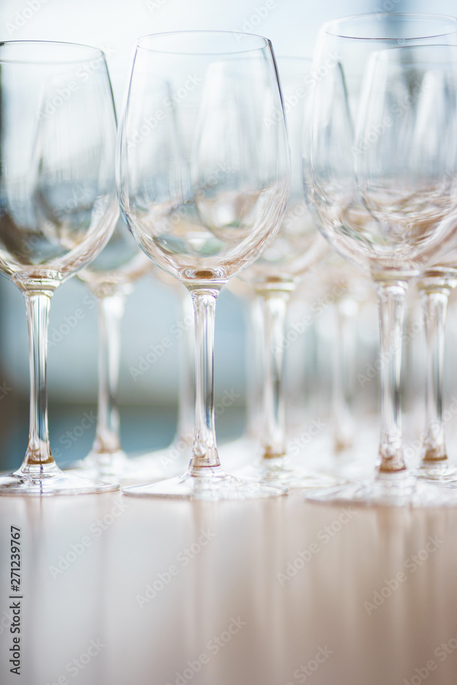 Several rows clear, clean glasses for wine and champagne on counter prepared for drinks. Several rows clear, clean glasses for wine and champagne on counter prepared for drinks.