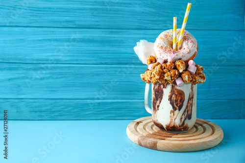 Delicious freak shake on color wooden background photo