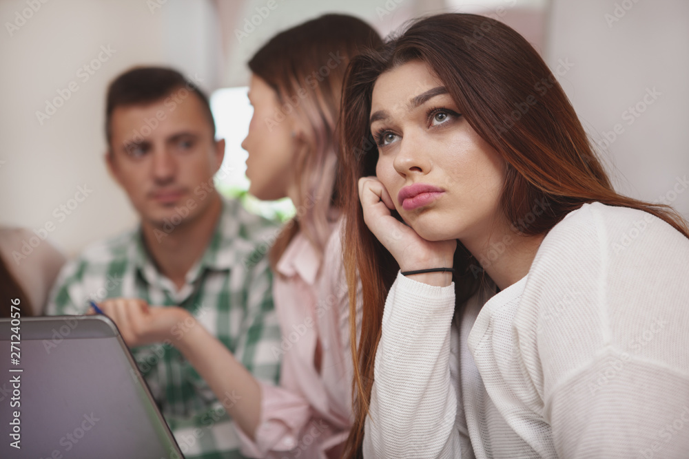 Overworking, boredom concept. Close up of a beautiful female college student looking bored during class. Attractive young woman student looking tired of studying Overworking, boredom concept. Close up of a beautiful female college student looking bored during class. Attractive young woman student looking tired of studying