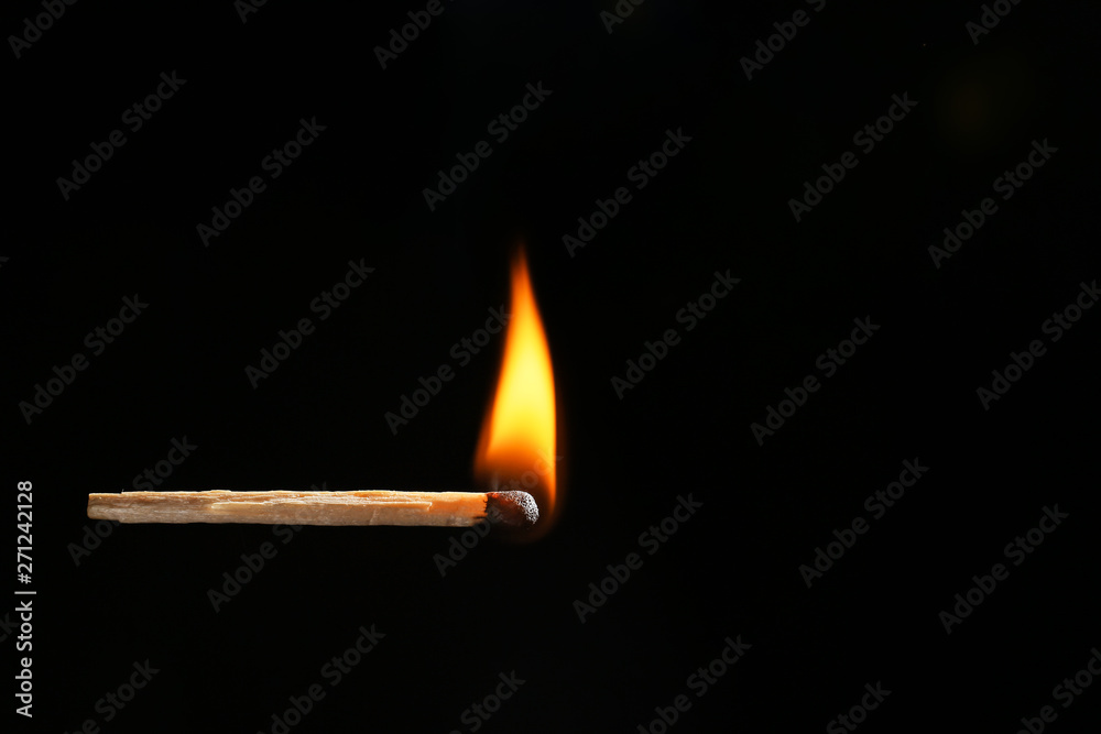 Burning match on dark background