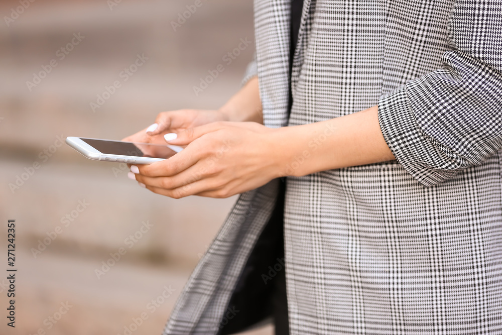 Young businesswoman with mobile phone outdoors