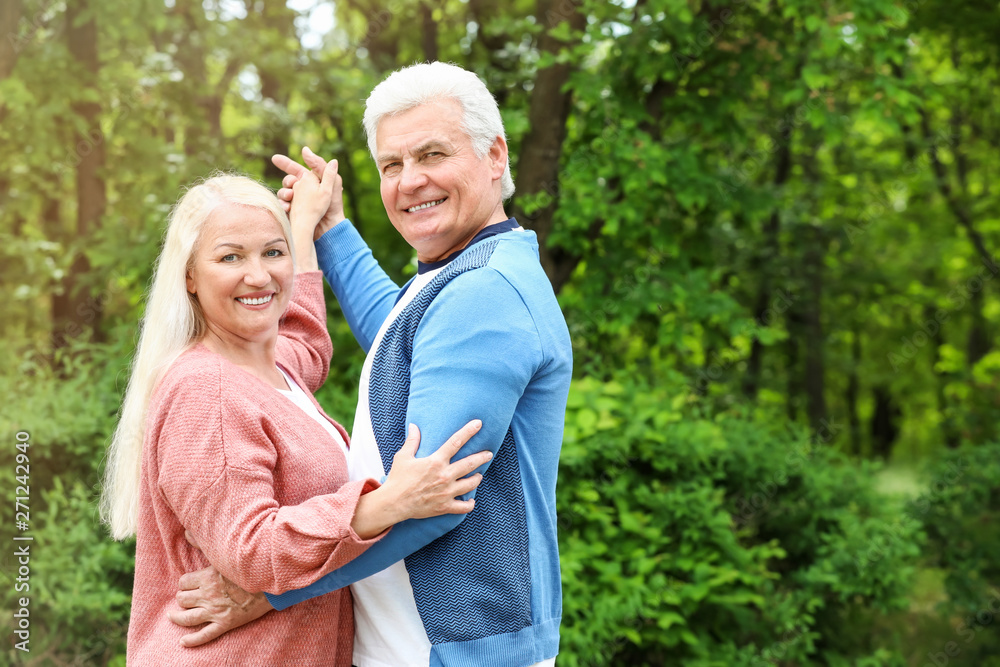 Portrait of happy mature couple dancing in park Portrait of happy mature couple dancing in park