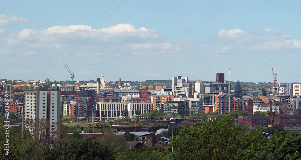 a wide cityscape view of leeds city centre taken from above showing office and apartment buildings the city hall and university area